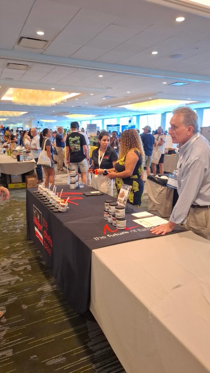 Attendees sampling food around a crowded vendor table